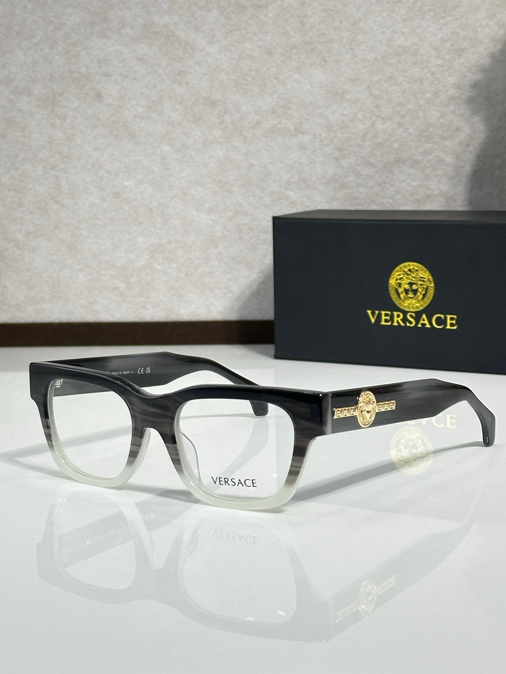 Versace eyeglasses with dark frame and gold Medusa emblem on the temple, clear lenses