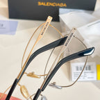Two Balenciaga eyeglasses with gold frames and dark blue temple accents