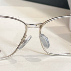 Balenciaga glasses close-up with clear lenses, gold bridge, and metal nose pads