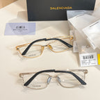 Two Balenciaga eyeglasses with gold-and-dark frames and clear lenses