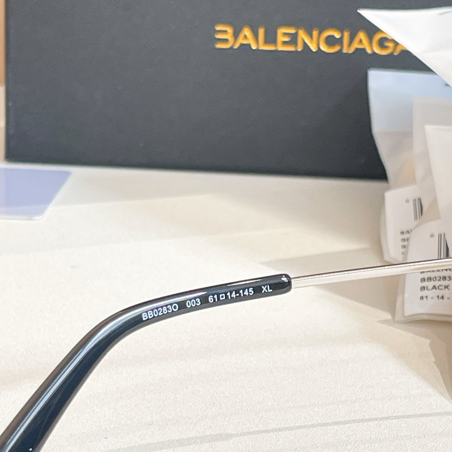 Balenciaga glasses close-up of dark blue temple with printed model details
