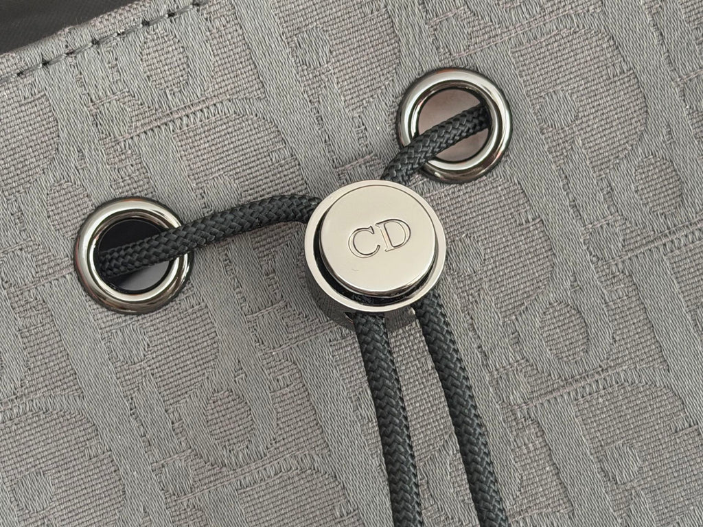 Dior men’s backpack close-up of drawstring eyelets and CD logo button hardware