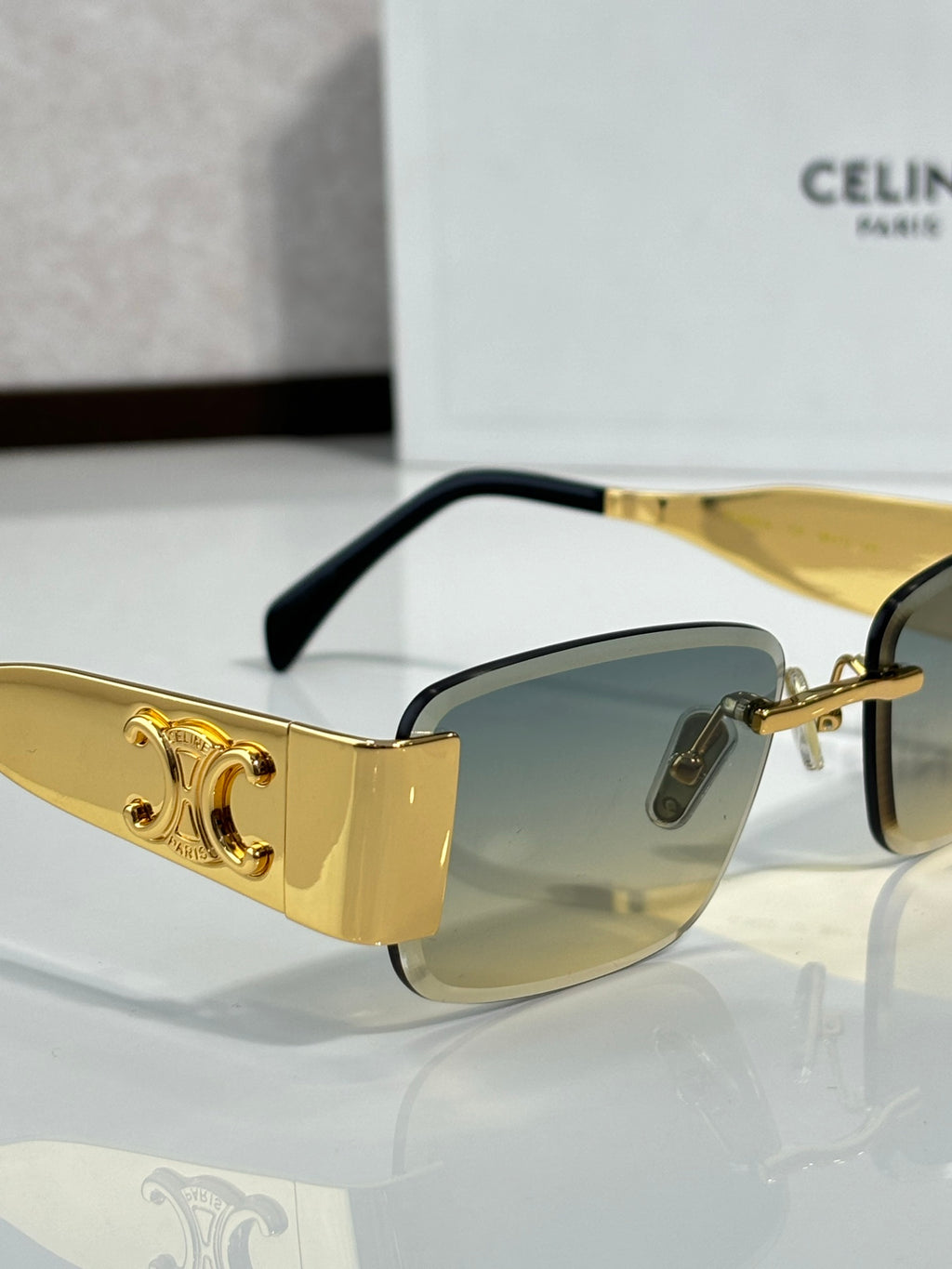 Gold rectangular sunglasses with amber gradient lenses and black temple tips