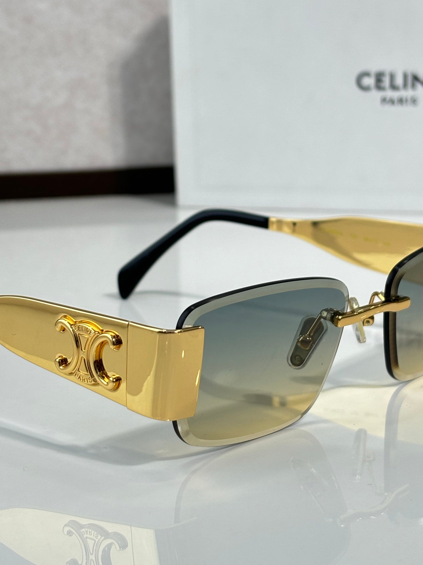 Gold rectangular sunglasses with amber gradient lenses and black temple tips
