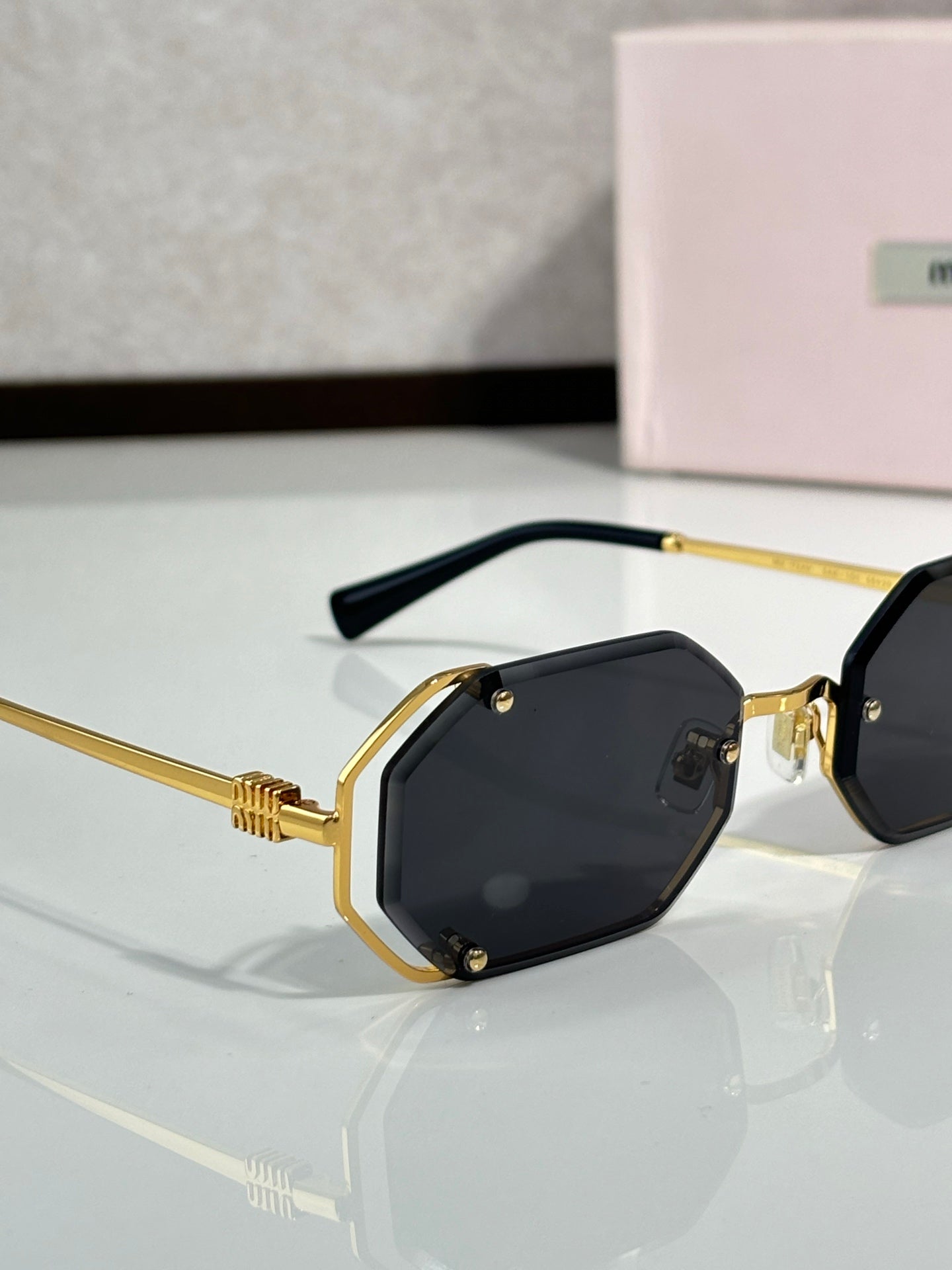 Miu Miu octagonal sunglasses, black lenses with gold frame, front view