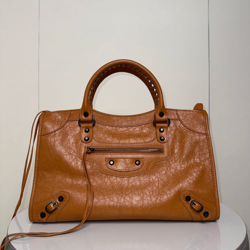 Balenciaga bag in tan leather with top handles and front zip pocket.
