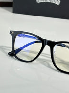 Close-up black full-rim eyeglasses with blue-tinted lens and metal temple