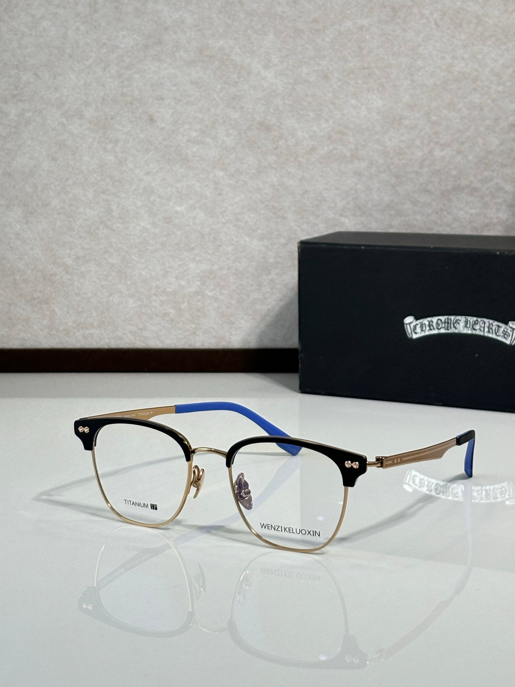 Eyeglasses with brown-and-black metal frame and blue temple accents, clear lenses