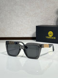 Versace eyeglasses, black frames, dark lenses, gold logo temple details.