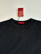 Black short-sleeve T-shirt close-up: crew neck with Gucci label, all-over pattern