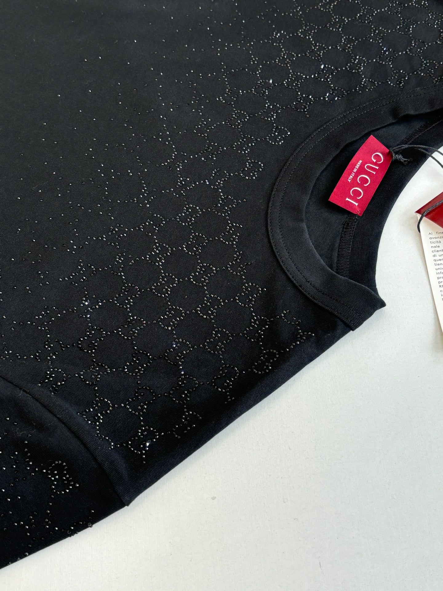 Black short-sleeve T-shirt sleeve close-up with Gucci neck tag