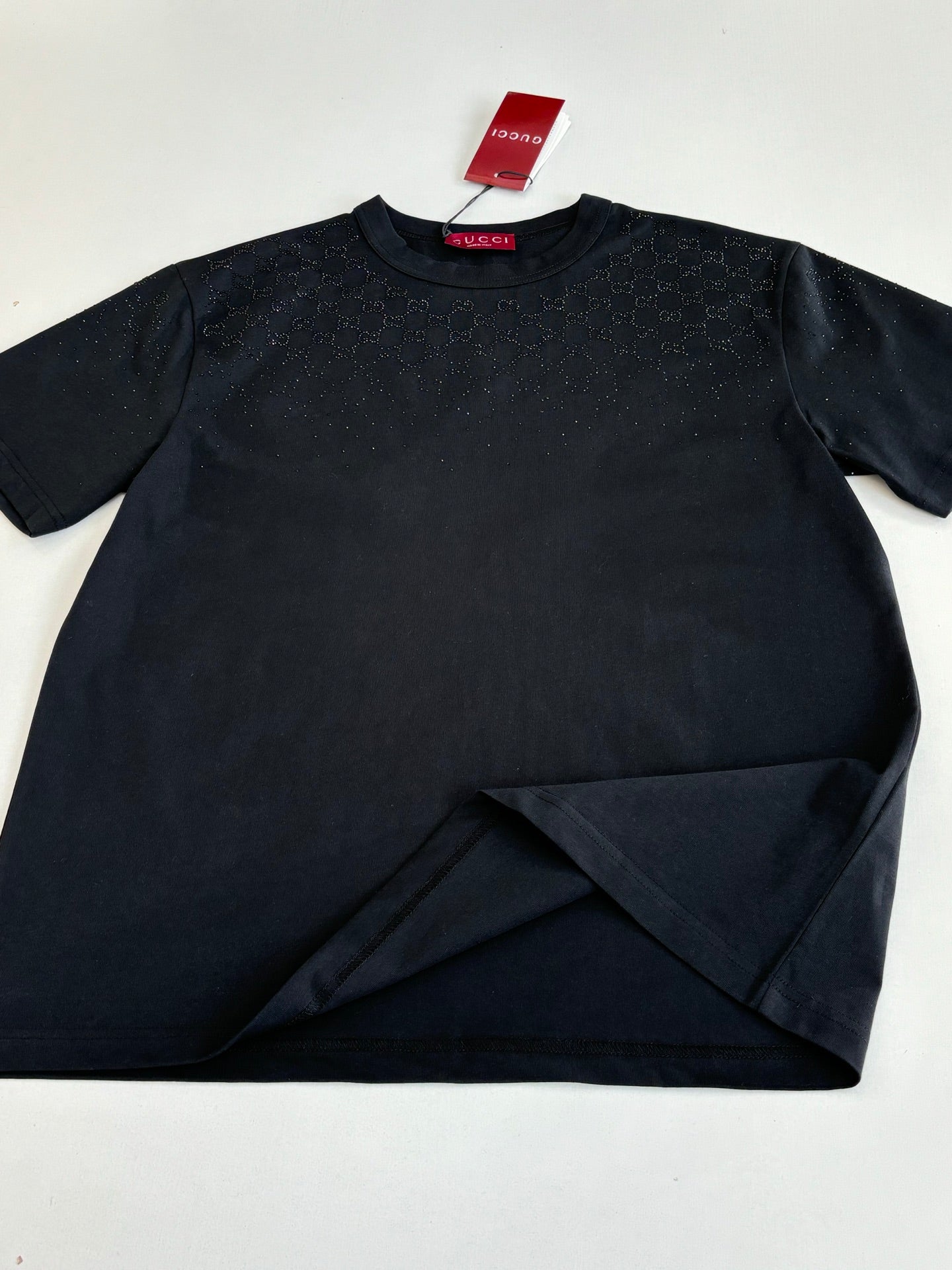 Black short-sleeve T-shirt laid flat with red Gucci neck label