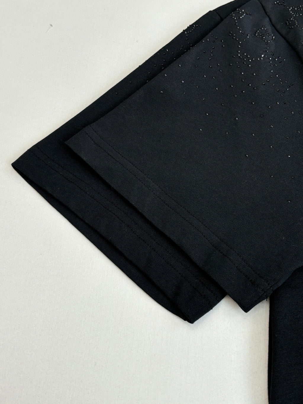 Black short-sleeve T-shirt fabric and sleeve edge close-up