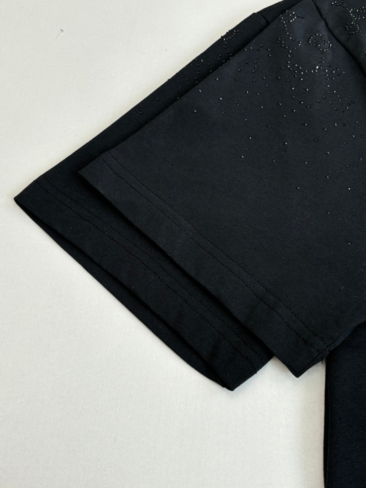 Black short-sleeve T-shirt fabric and sleeve edge close-up