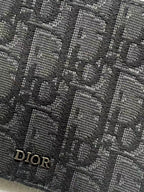 Small bag with Dior monogram fabric close-up in dark navy with Dior mark.