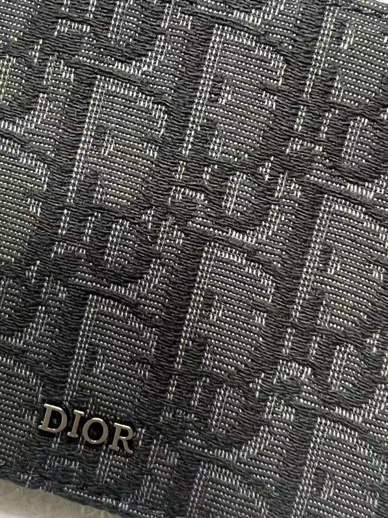 Small bag with Dior monogram fabric close-up in dark navy with Dior mark.