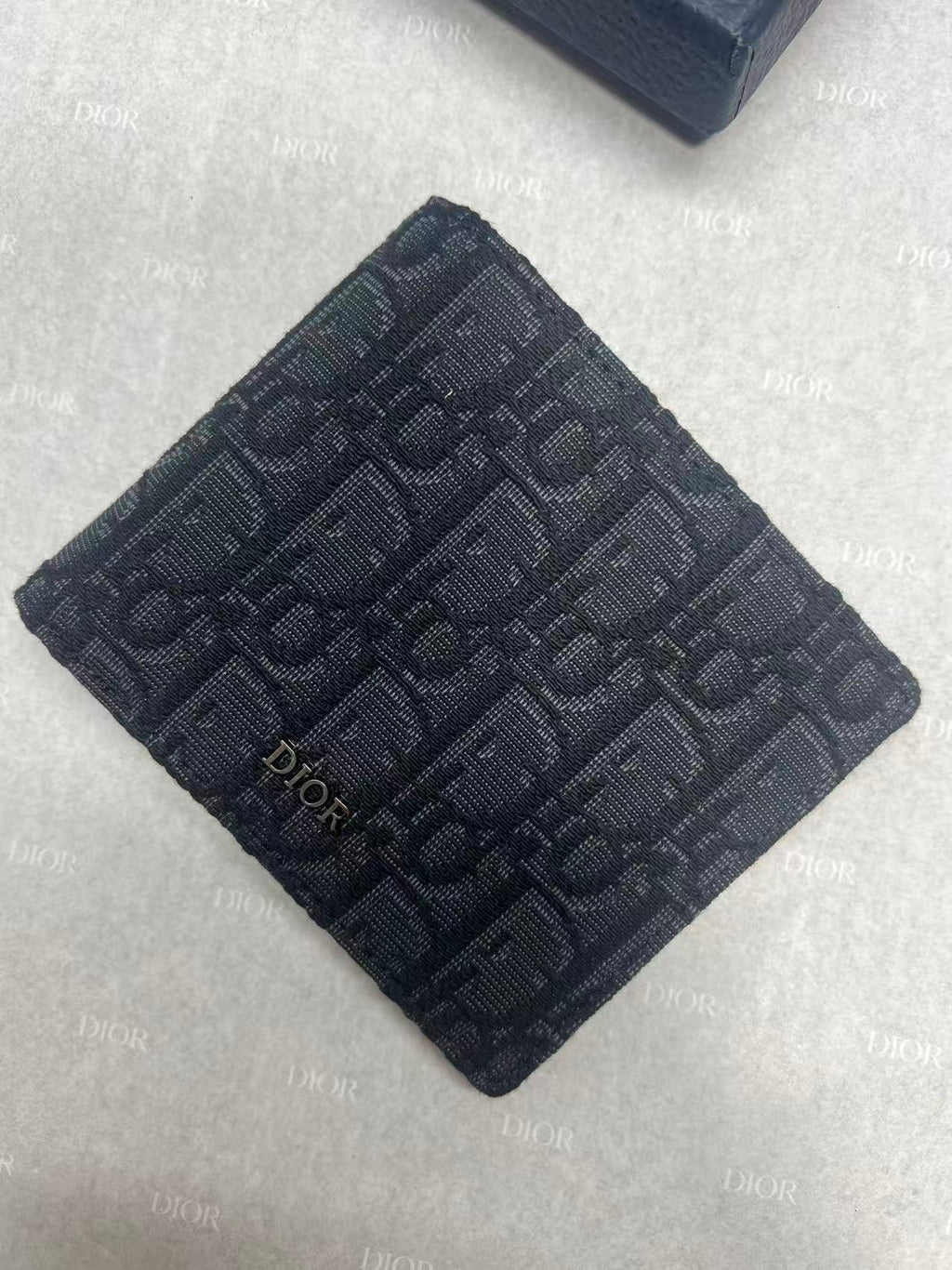 Small bag with Dior monogram fabric, navy, square folded front view.