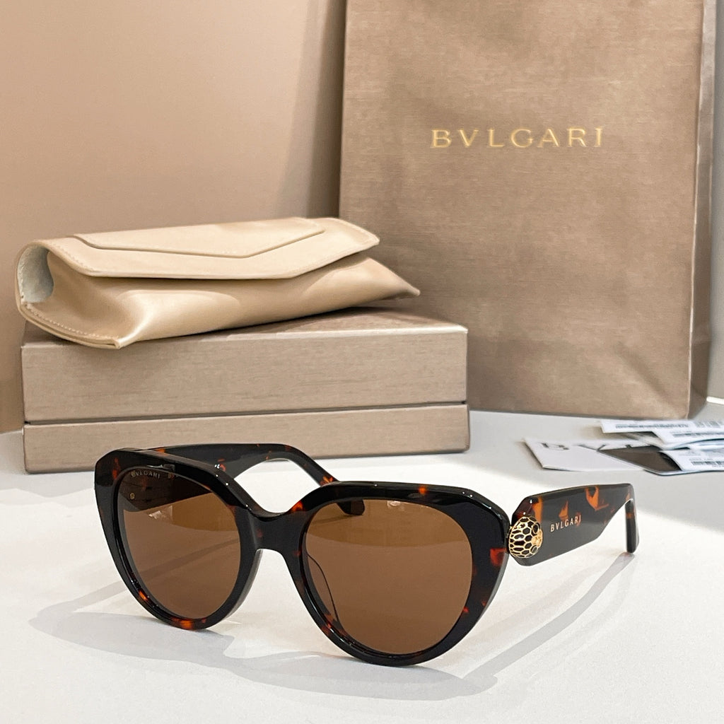 Tortoiseshell round eyeglasses with thick frame and gold logo emblem on temple.