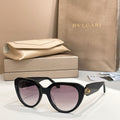 Black round eyeglasses with thick frame, gold logo detail on temple.
