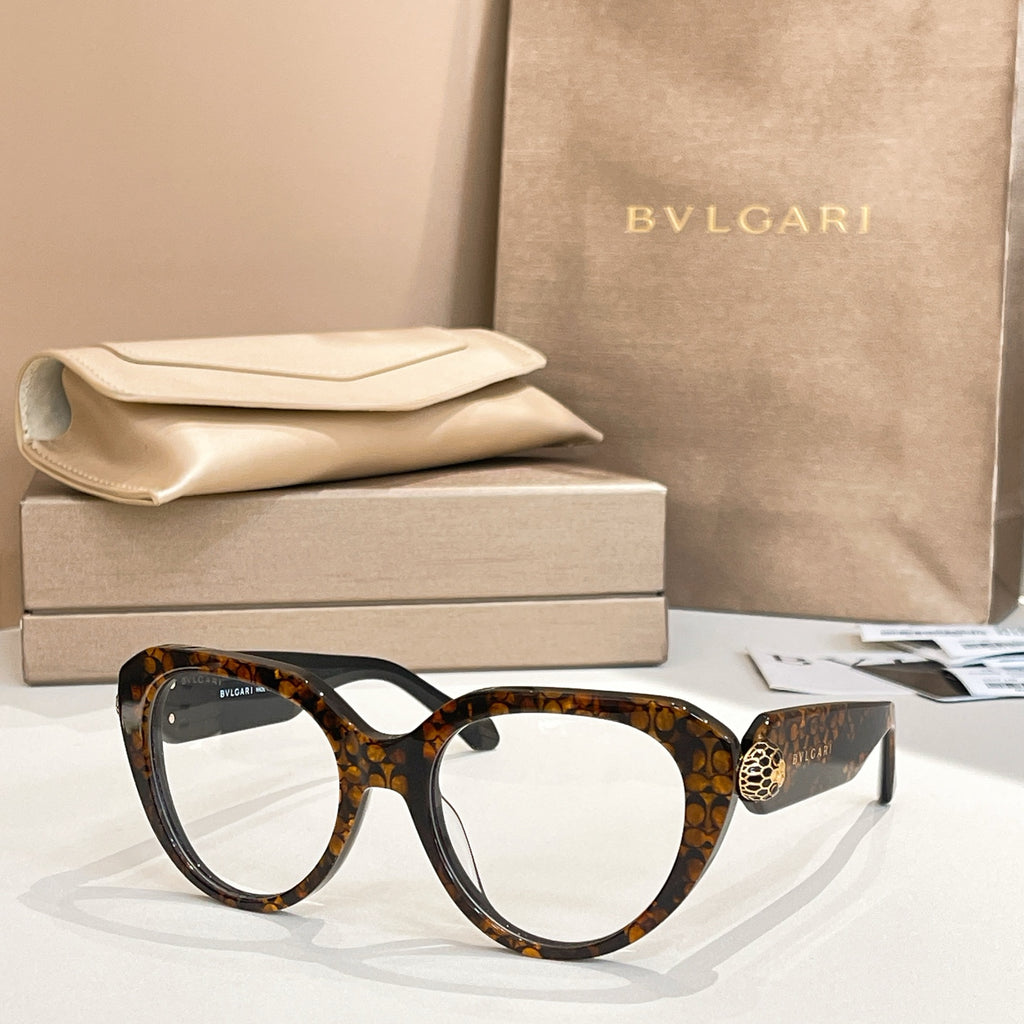 Tortoiseshell round eyeglasses with thick frame, gold logo emblem on temple.