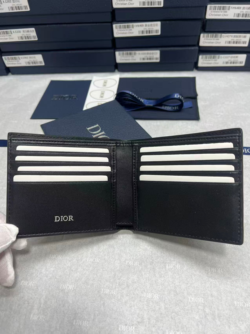 Small leather wallet, open interior with card slots and Dior logo on panels