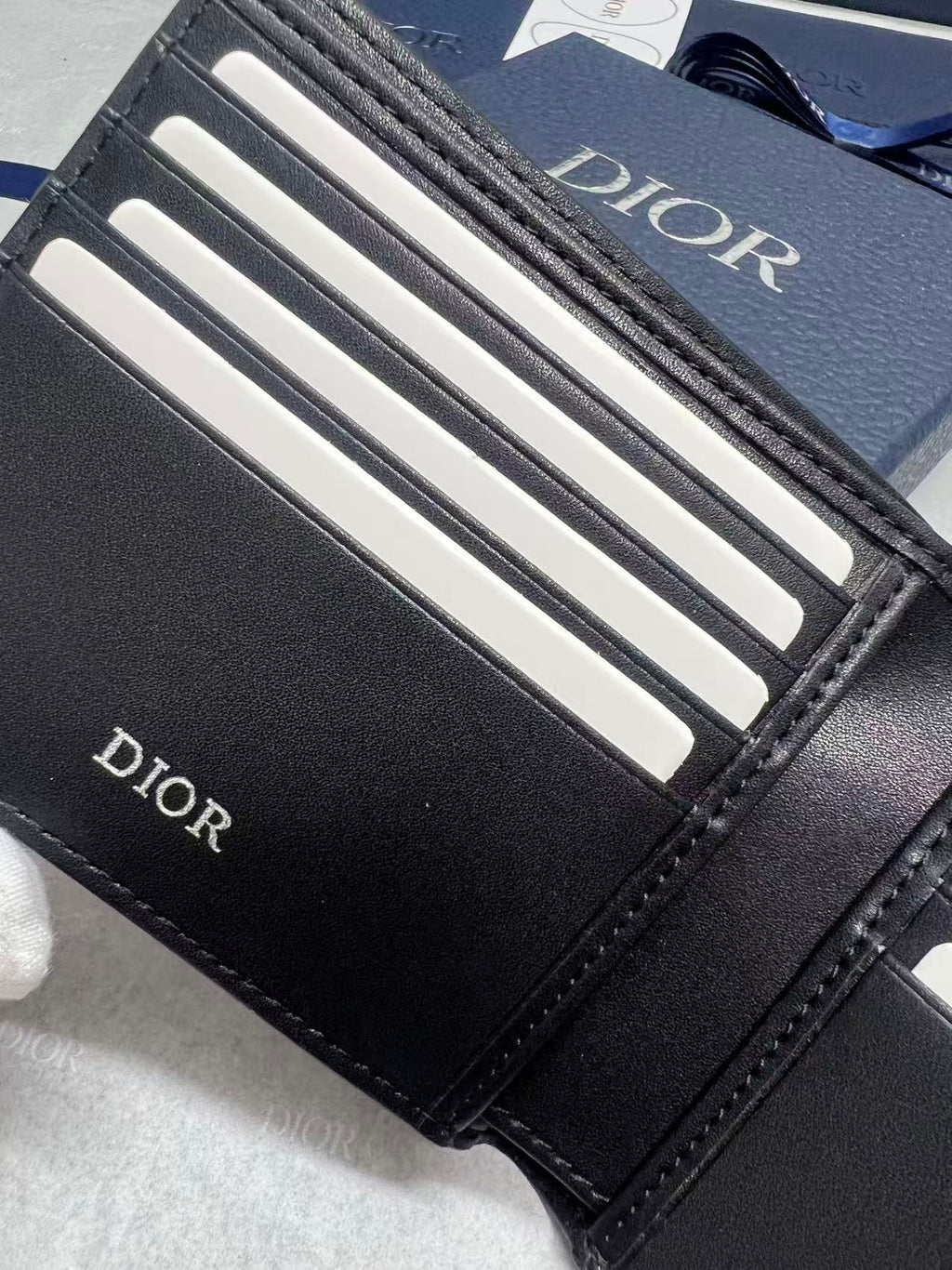 Small leather wallet, close-up of black card slots with Dior branding