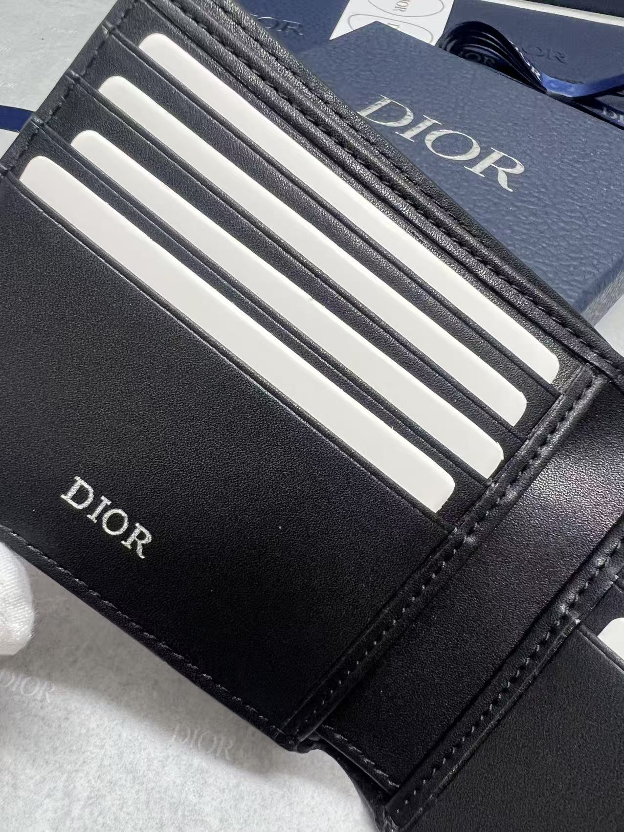 Small leather wallet, close-up of black card slots with Dior branding