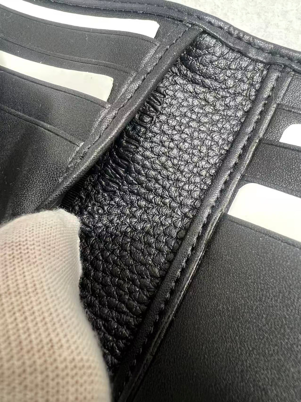 Black leather small wallet close-up of card slot lining with stitched edge