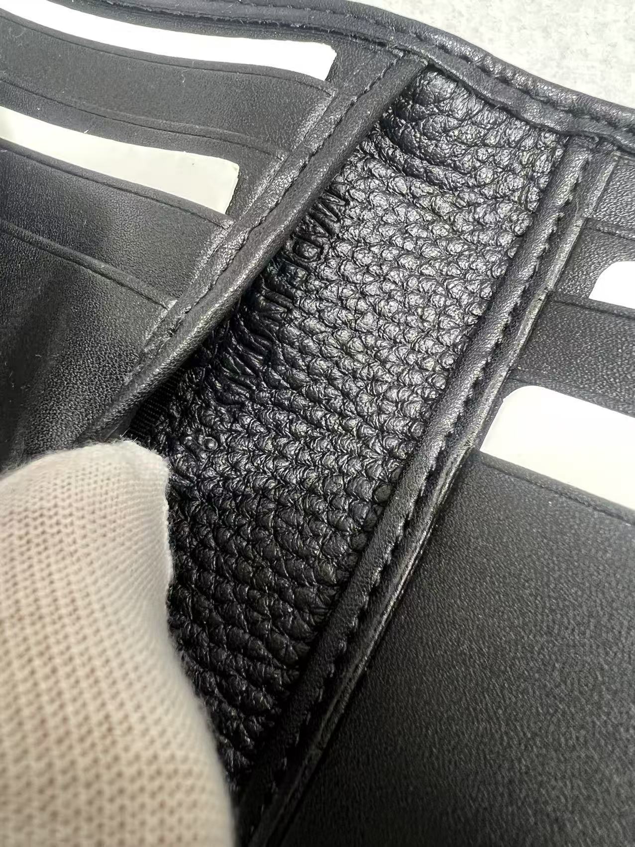 Black leather small wallet close-up of card slot lining with stitched edge