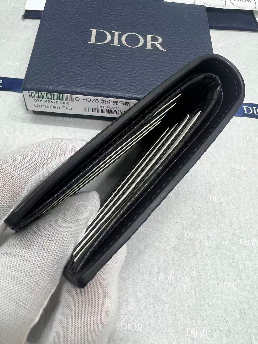Black leather small wallet with accordion-style interior compartments and Dior logo