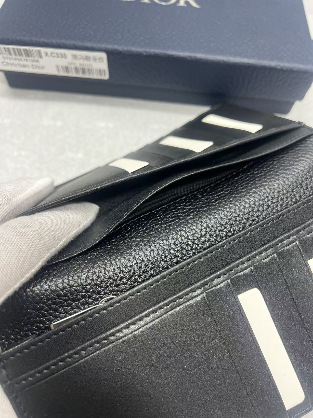 Dior small bag close-up, stitched flap edge and smooth leather panel