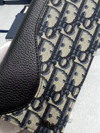 Dior small bag close-up: black leather edge with woven monogram canvas panel