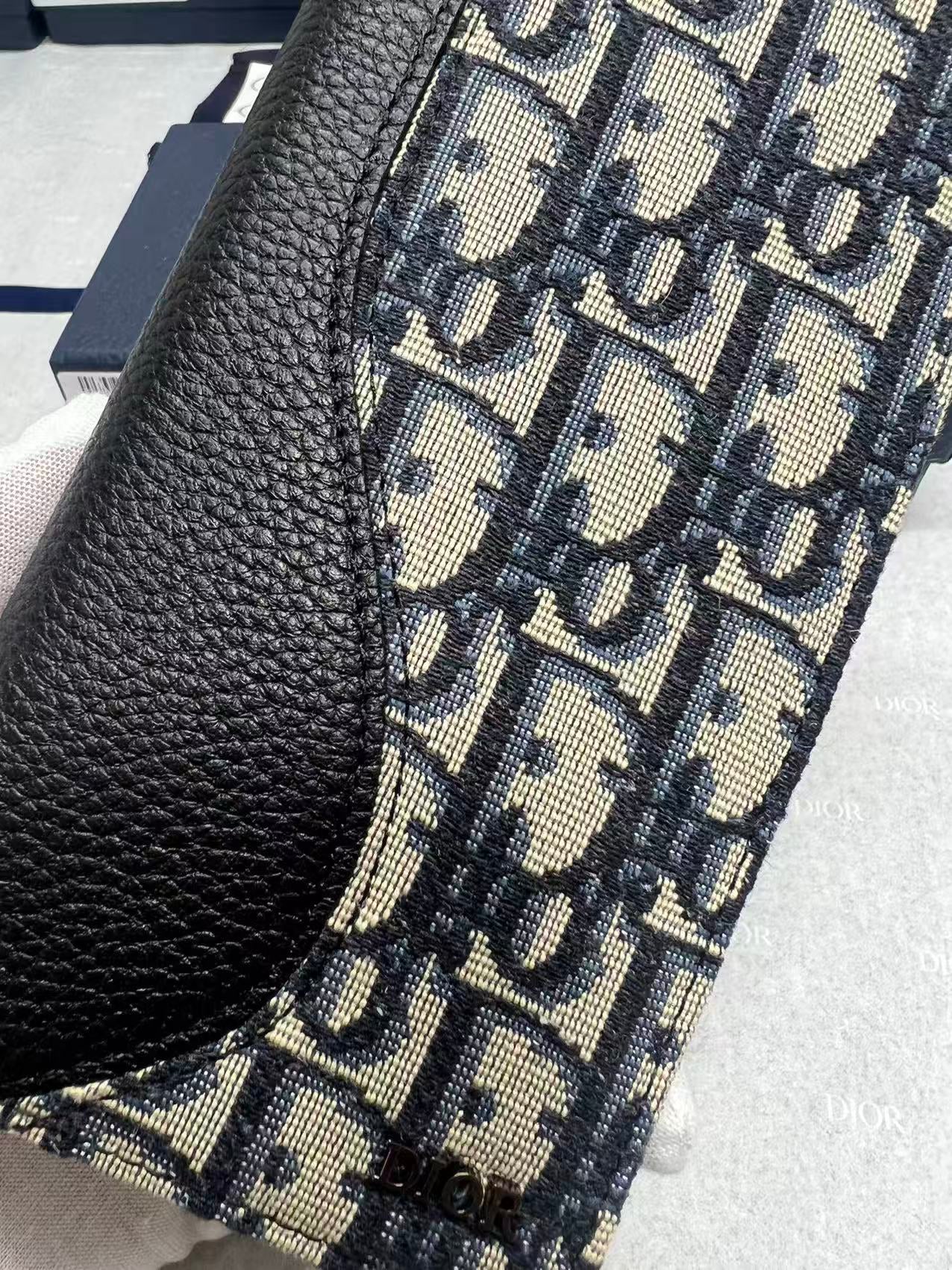 Dior small bag close-up: black leather edge with woven monogram canvas panel