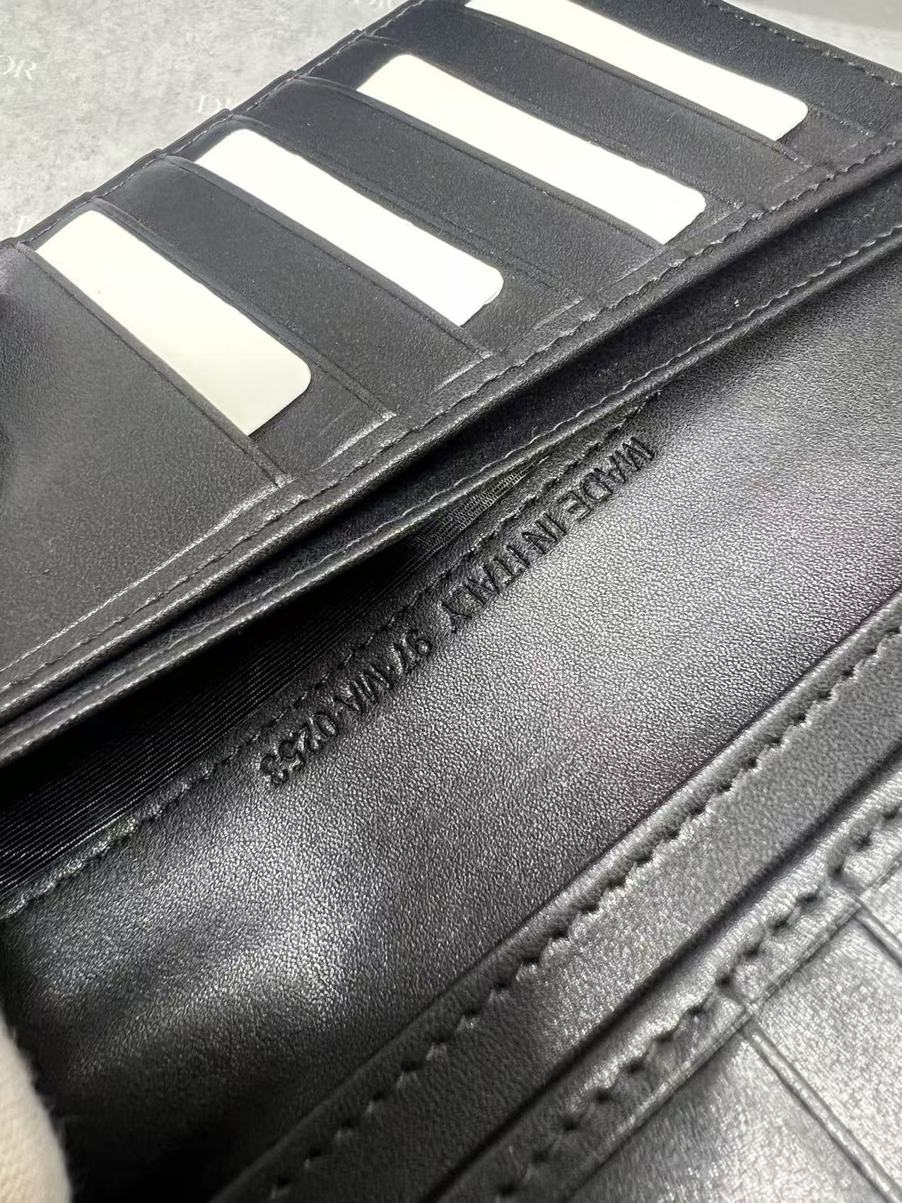 Black leather wallet interior close-up with card slots and visible stitching