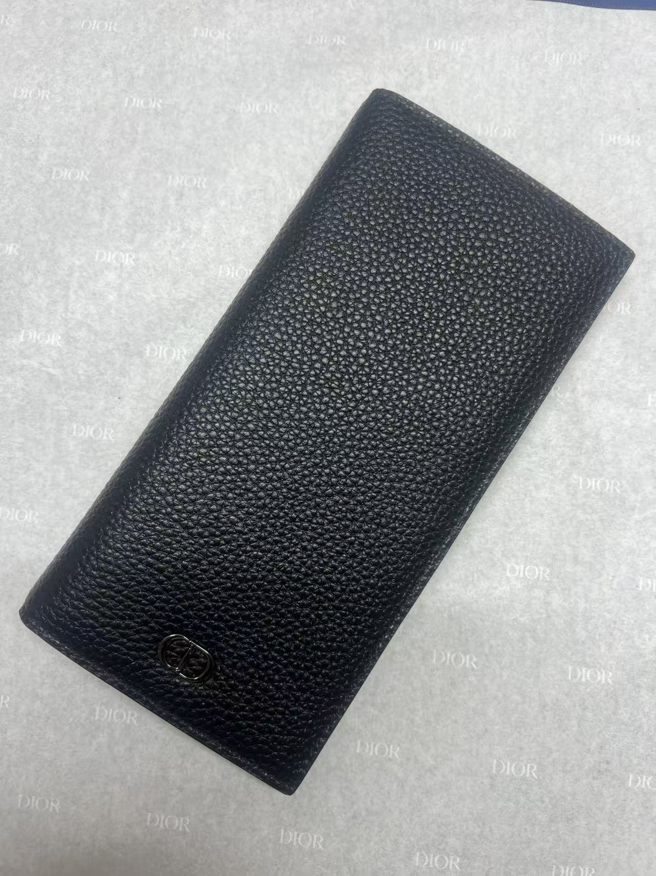 Dior small leather wallet with textured finish and embossed logo, angled view