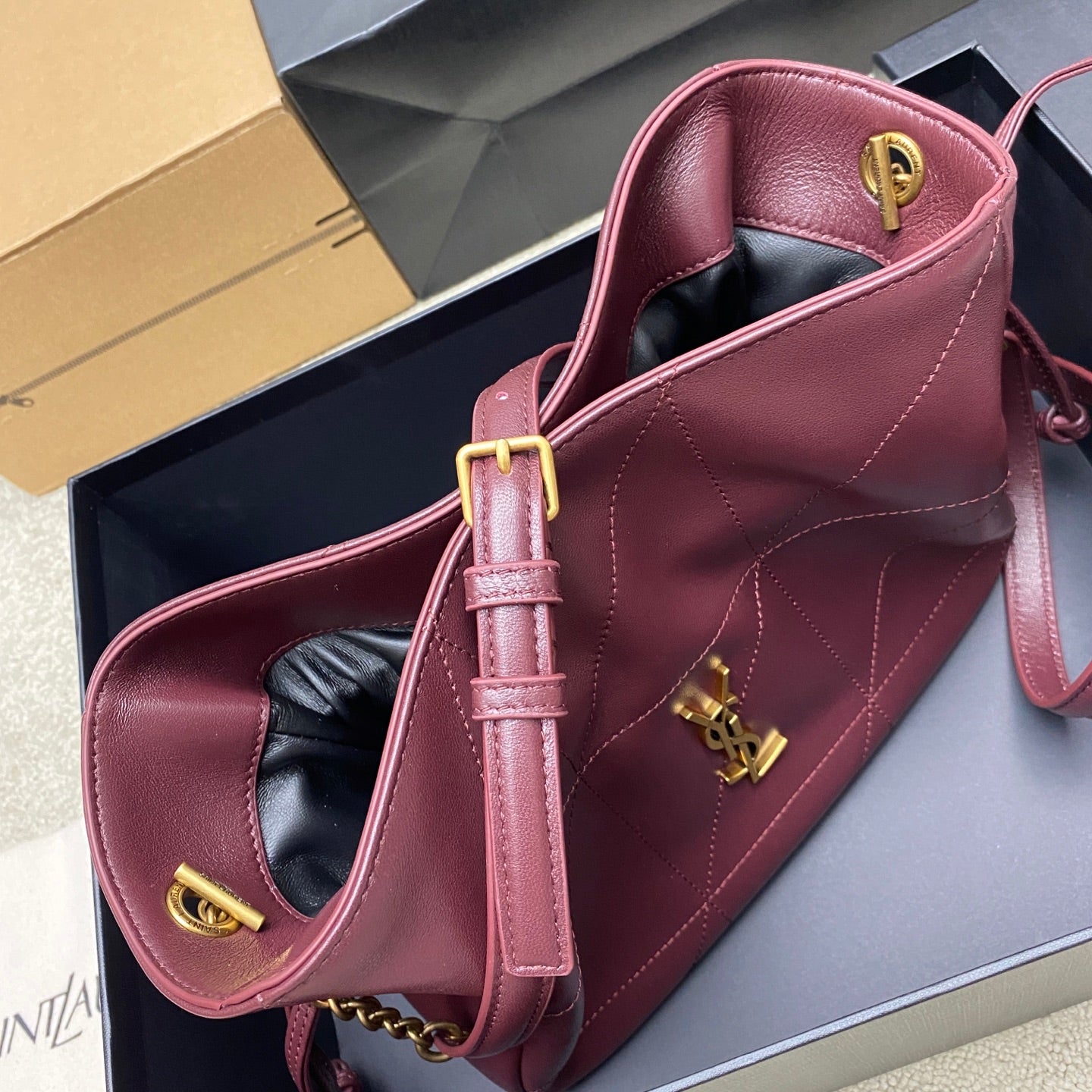 YSL pink quilted leather bag with gold hardware, top handle, and shoulder strap