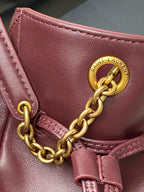 YSL pink leather bag detail with gold chain, Saint Laurent emblem, and stitching