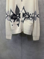 Cream knit cardigan with black patterned front and matching pocket on the left side