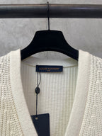 Cream knit cardigan on a hanger with V-neck and Louis Vuitton size label