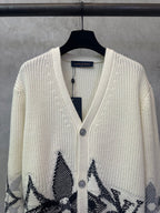 Cream knit cardigan with V-neck and black patterned designs on the front panels