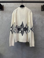 Cream knit cardigan with black geometric pattern across sleeves and lower front