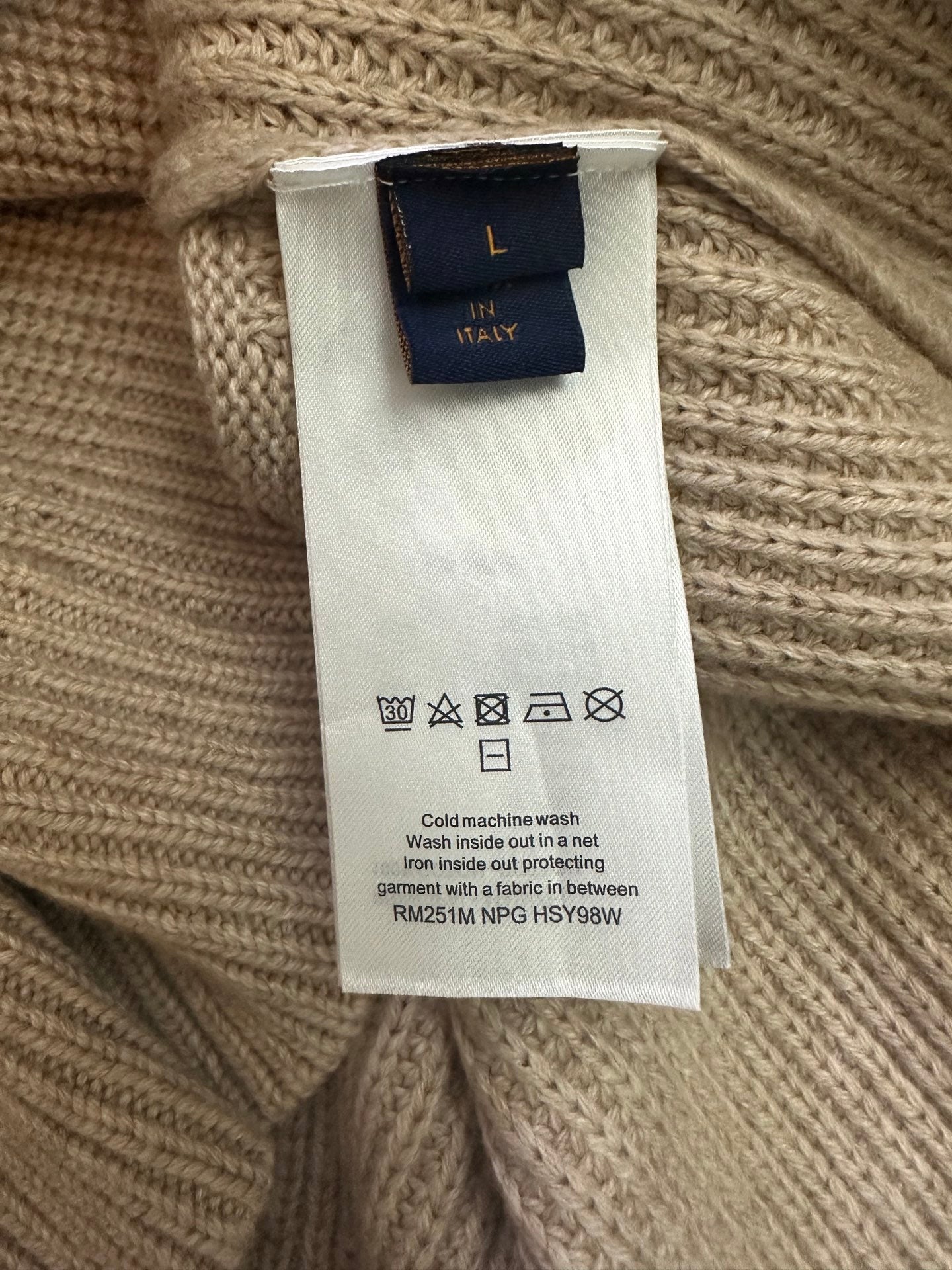 Beige sweater care label with size and wash instructions