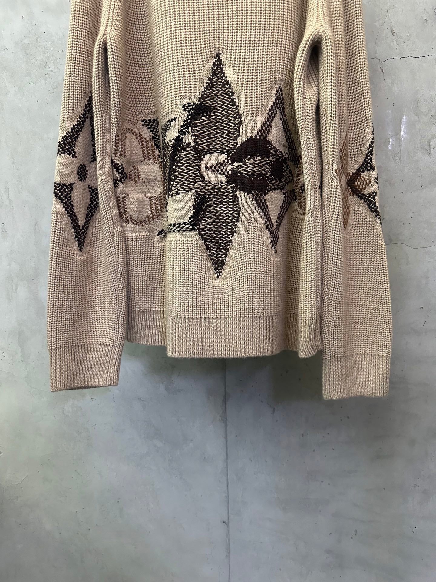 Beige knit sweater with long sleeves and central black geometric diamond motif
