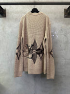 Beige knit sweater with long sleeves and black geometric diamond back design