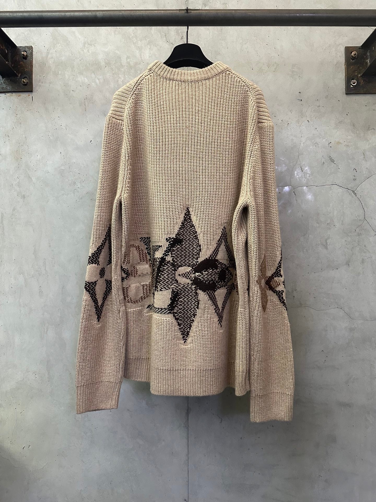 Beige knit sweater with long sleeves and black geometric diamond back design