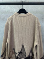 Beige knit sweater with long sleeves and black geometric diamond graphic on back