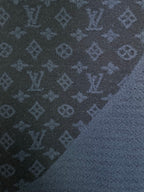 Dark blue knit fabric with repeating monogram pattern