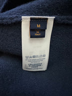 Clothing label on dark blue knit, 'M in Italy' and care/wash instructions