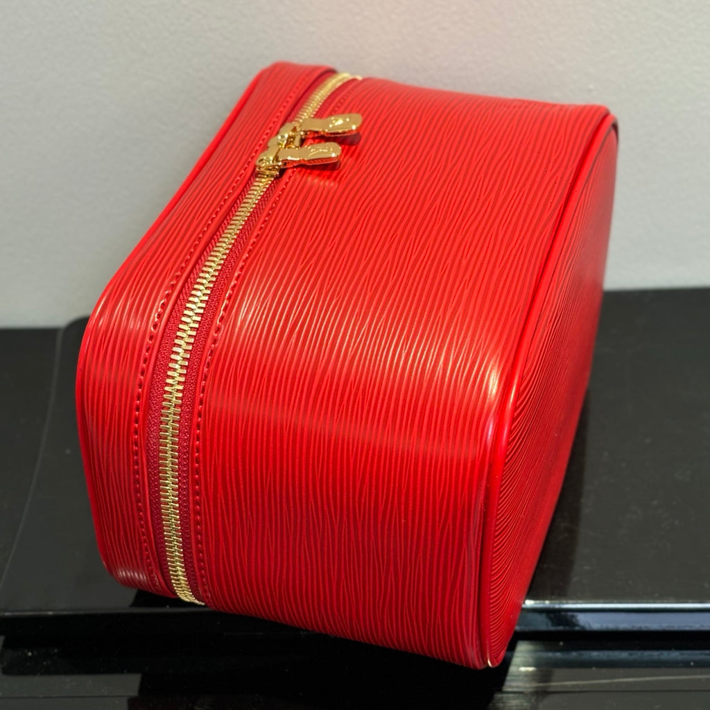 Louis Vuitton red cosmetic bag side view with gold zipper trim and handle.