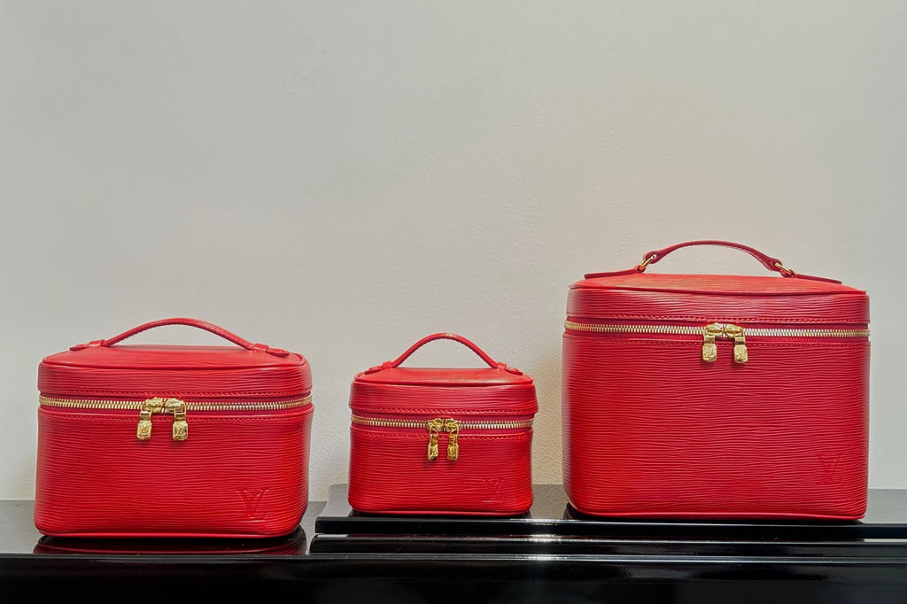 Louis Vuitton red cosmetic bag set: small, medium, and large cases with handles.